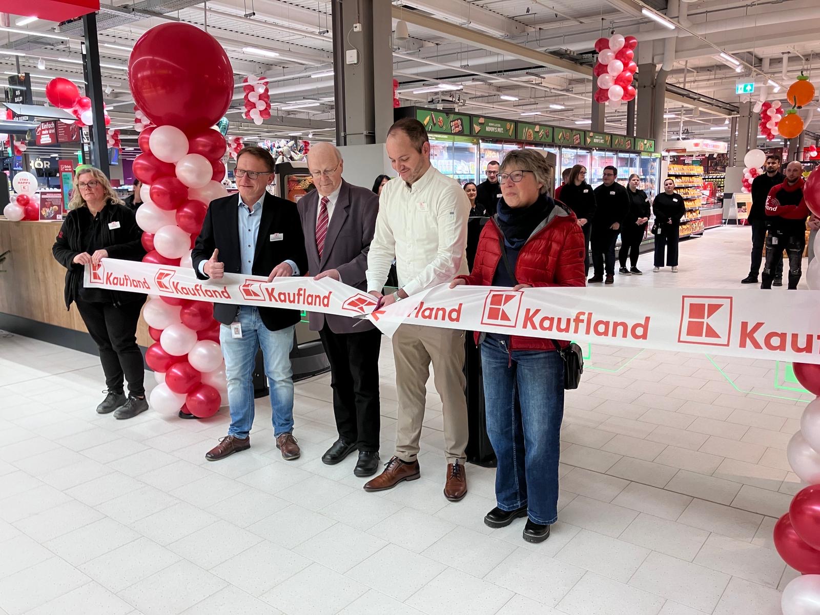 Marktleiter Sven Erbach durchschneidet gemeinsam mit lokalen Vertreterinnen und Vertretern das Eröffnungsband im neuen Kaufland-Markt in Göttingen-Weende